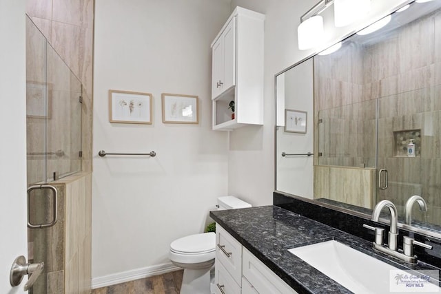 bathroom featuring wood-type flooring, vanity, toilet, and an enclosed shower