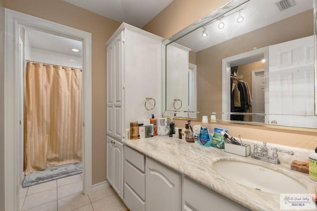 bathroom featuring tile patterned flooring, vanity, and walk in shower