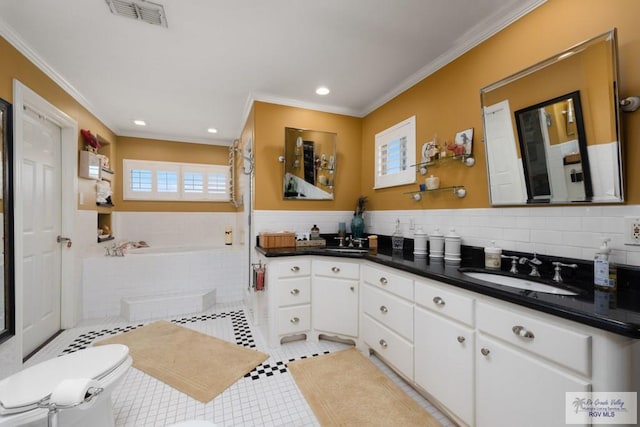 bathroom featuring toilet, crown molding, vanity, tile patterned flooring, and a washtub