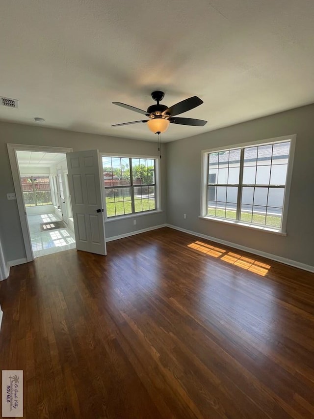 unfurnished room featuring dark hardwood / wood-style floors and ceiling fan