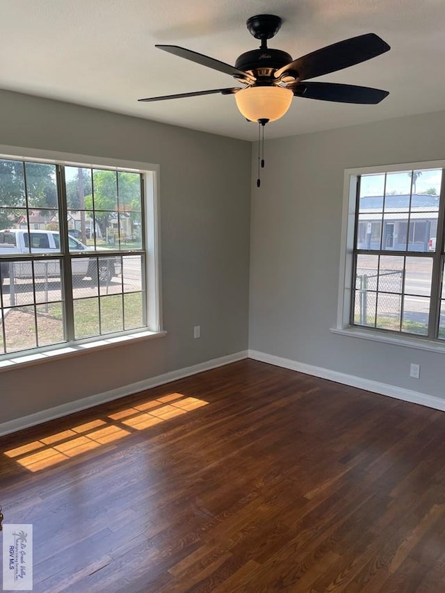 unfurnished room featuring dark hardwood / wood-style flooring, ceiling fan, and a healthy amount of sunlight