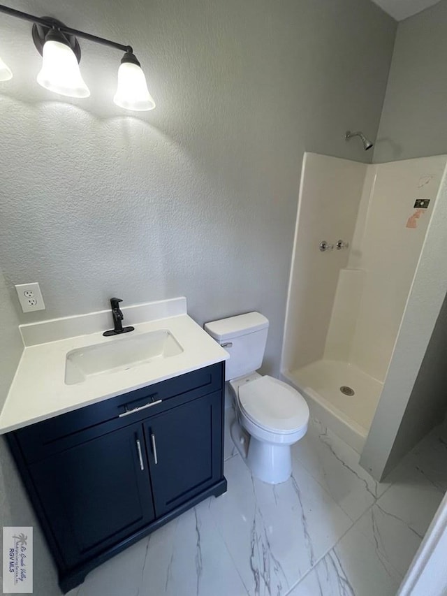 bathroom with toilet, vanity, and walk in shower