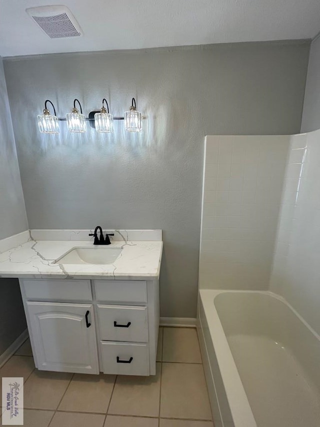 bathroom with tile patterned flooring, vanity, and tub / shower combination