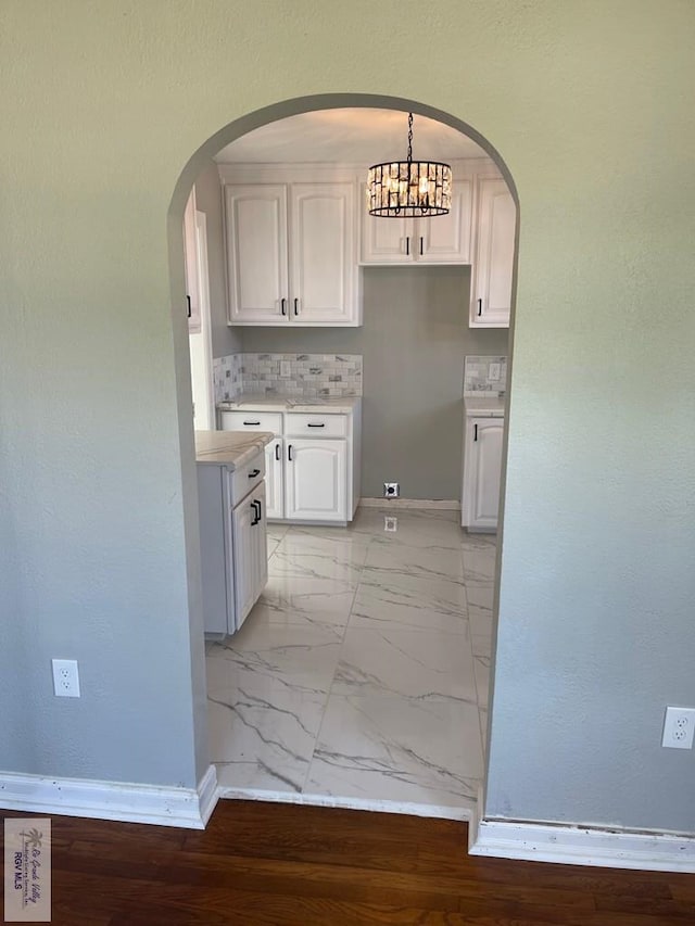 kitchen with white cabinetry, decorative light fixtures, and an inviting chandelier