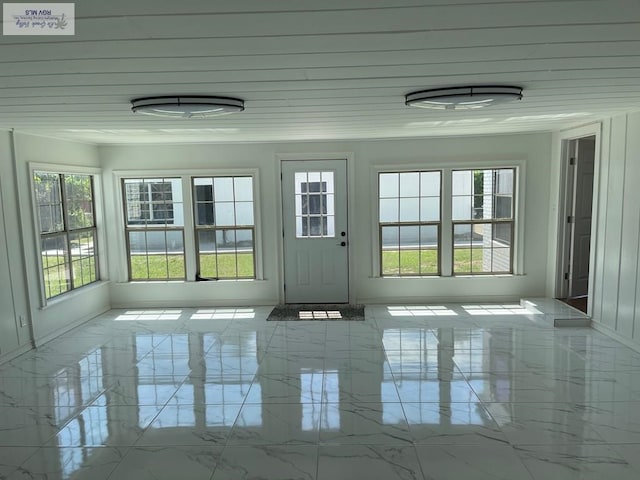 unfurnished sunroom with a healthy amount of sunlight and wooden ceiling