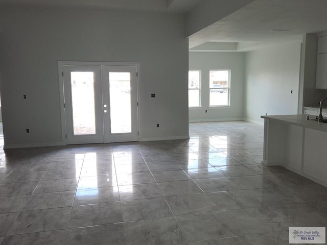 interior space featuring french doors, light tile patterned floors, and sink