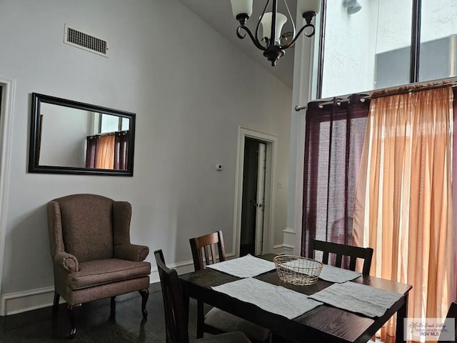 dining area with visible vents, baseboards, a chandelier, and high vaulted ceiling