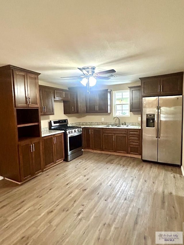 kitchen featuring dark brown cabinetry, a ceiling fan, stainless steel appliances, light wood-style floors, and a sink