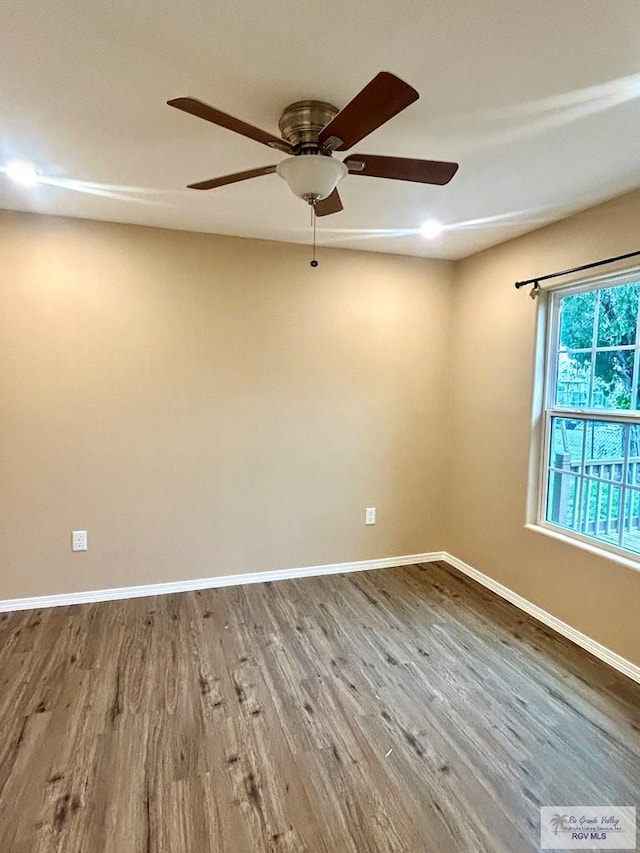 empty room featuring baseboards and wood finished floors