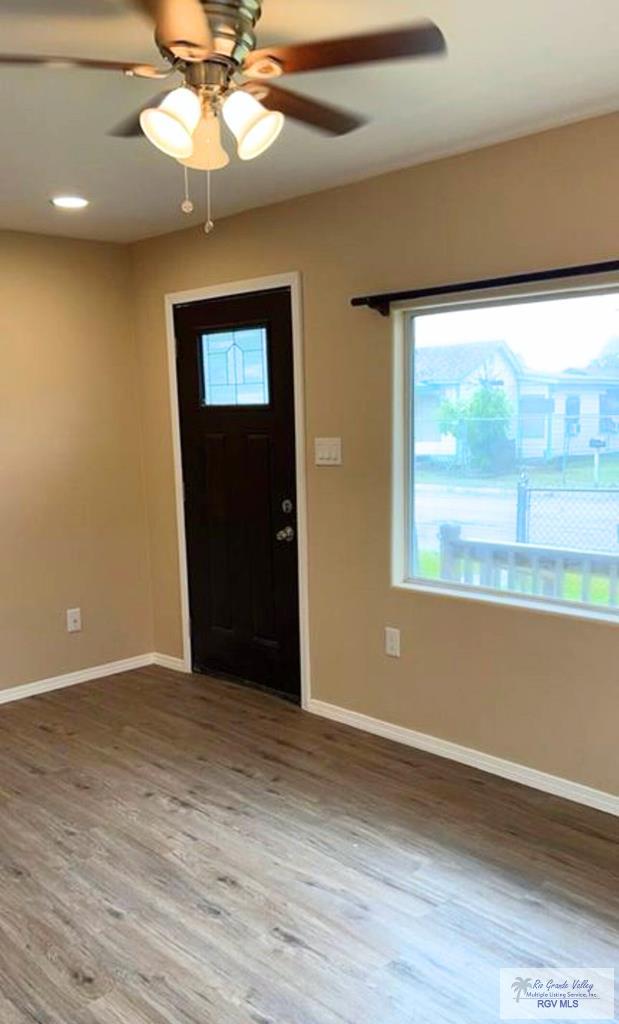 foyer entrance featuring ceiling fan, baseboards, and wood finished floors