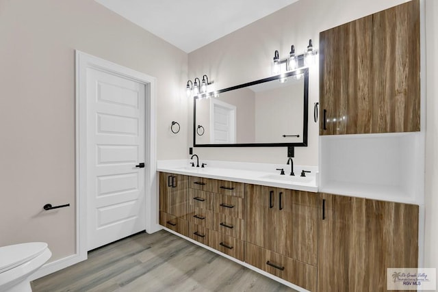 3330 Calle Bolivia, Brownsville, TX 78521 - full bathroom with double vanity, wood finished floors, and toilet