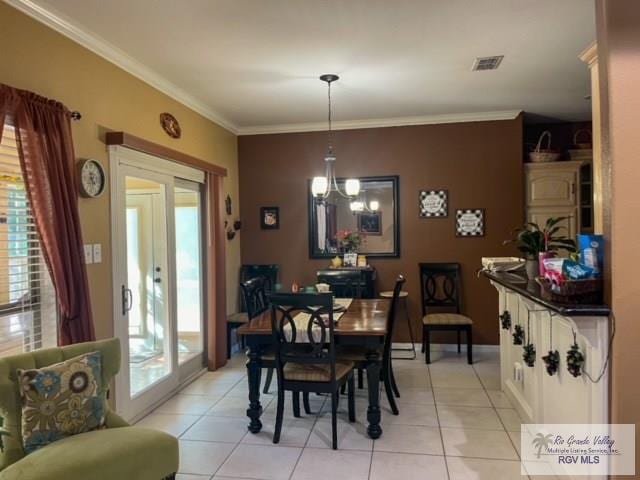 dining room with crown molding, french doors, light tile patterned floors, and an inviting chandelier