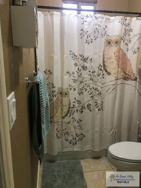 bathroom with tile patterned floors, water heater, and toilet