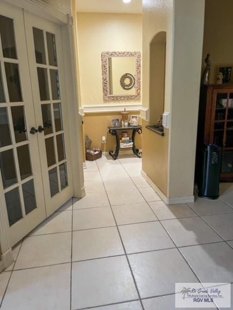 hall with tile patterned flooring and french doors