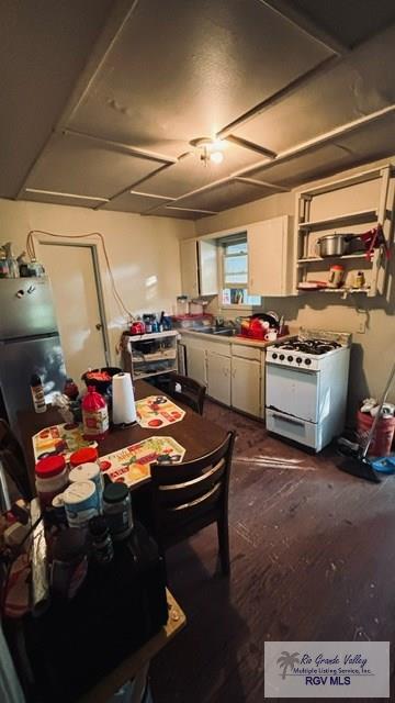 kitchen with white cabinetry, dark hardwood / wood-style floors, and white gas range oven