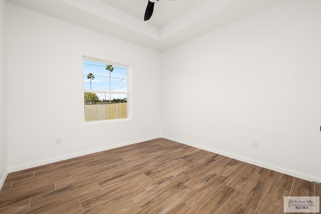 unfurnished room with a raised ceiling and ceiling fan