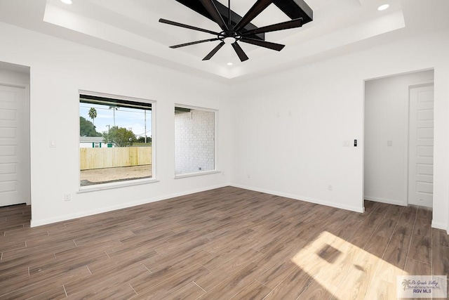 spare room featuring a tray ceiling and ceiling fan