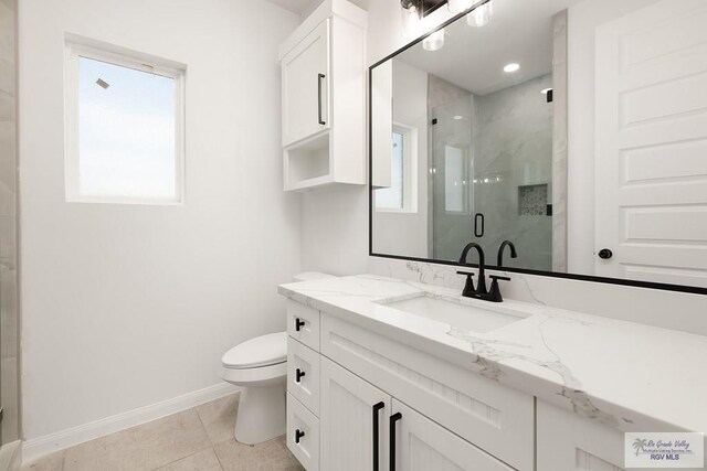 bathroom with tile patterned floors, vanity, toilet, and a shower with door