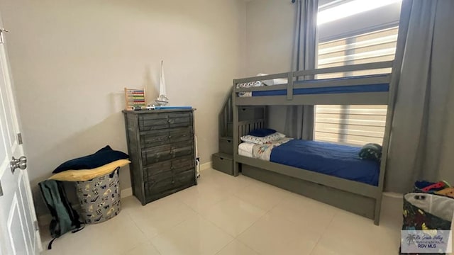 bedroom with baseboards and tile patterned floors