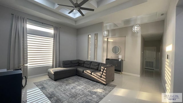 living area with visible vents, baseboards, coffered ceiling, and a ceiling fan