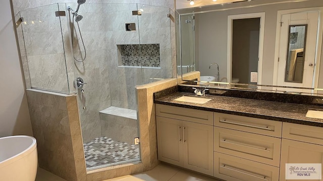 bathroom with a freestanding bath, double vanity, a sink, and a shower stall