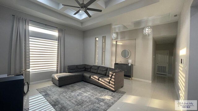 living room featuring a ceiling fan, visible vents, baseboards, and light tile patterned flooring