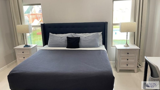 bedroom featuring light tile patterned flooring and baseboards