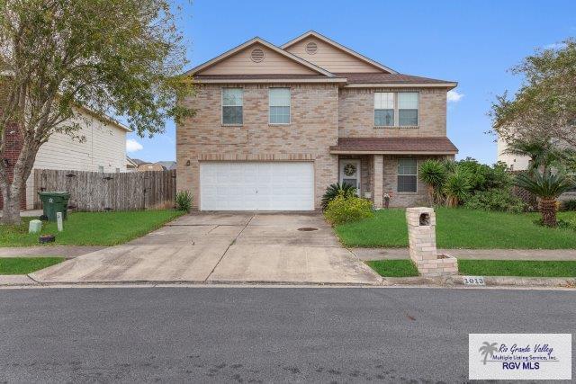 1013 Champlain Dr, Brownsville, TX 78526 - traditional home with an attached garage, driveway, and brick siding