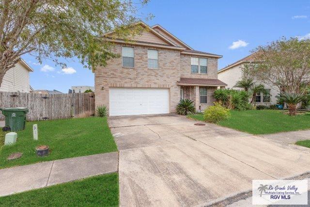1013 Champlain Dr, Brownsville, TX 78526 - traditional-style home with an attached garage, concrete driveway, and brick siding