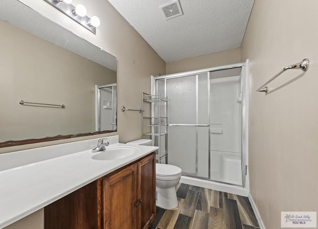 1013 Champlain Dr, Brownsville, TX 78526 - bathroom featuring a stall shower, wood finished floors, vanity, and a textured ceiling