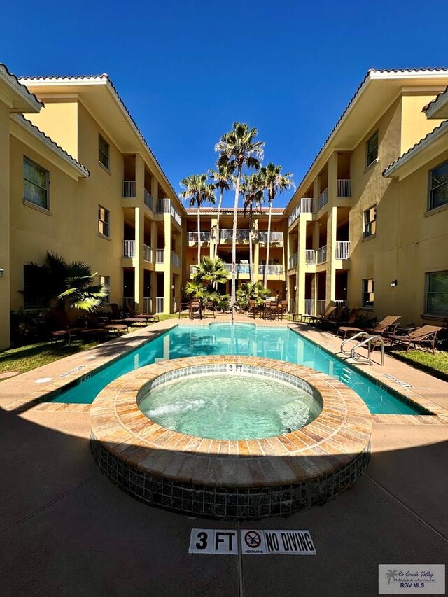 view of swimming pool with a community hot tub