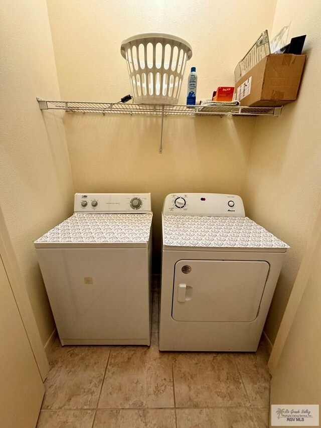 clothes washing area with separate washer and dryer and light tile patterned floors