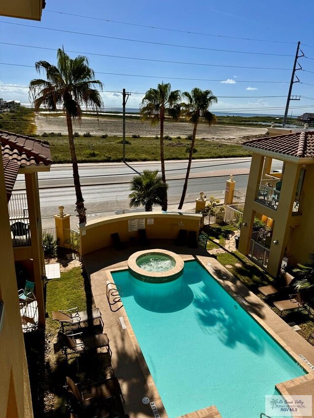 view of pool with a patio area and an in ground hot tub