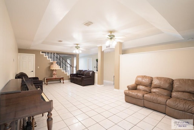 living room featuring ceiling fan and a tray ceiling