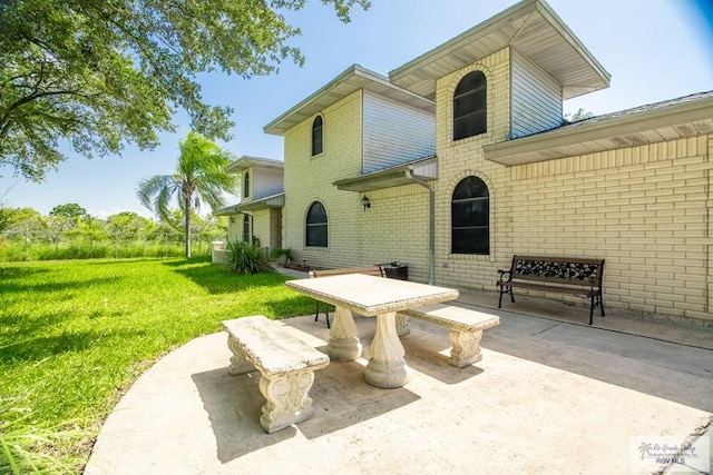 rear view of property featuring a patio area and a yard