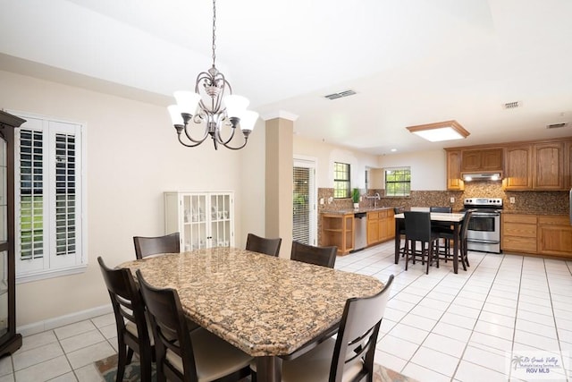 dining area with light tile patterned floors and an inviting chandelier