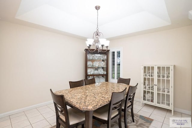 dining room with light tile patterned flooring, a raised ceiling, and an inviting chandelier