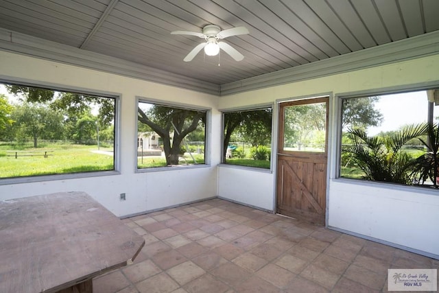 unfurnished sunroom with a wealth of natural light, wooden ceiling, and ceiling fan