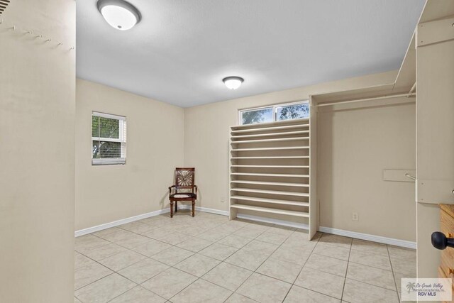 empty room with light tile patterned floors and a wealth of natural light