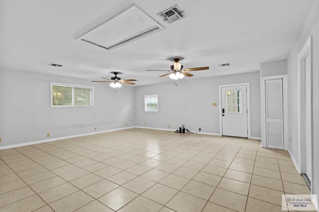 spare room with ceiling fan and light tile patterned floors