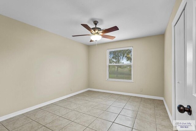 tiled empty room featuring ceiling fan