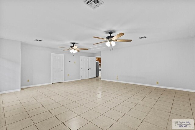 tiled spare room with ceiling fan