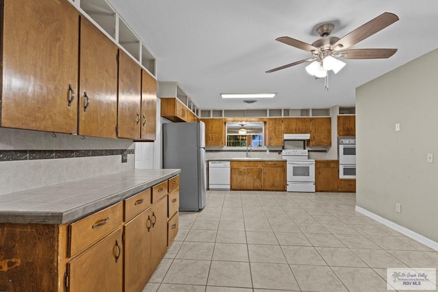 kitchen featuring ceiling fan, sink, white appliances, decorative backsplash, and light tile patterned floors