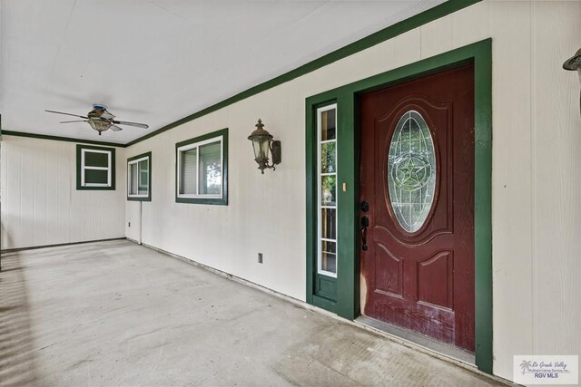 view of exterior entry with ceiling fan and covered porch