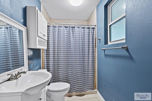 bathroom featuring vanity, tile patterned floors, toilet, a textured ceiling, and curtained shower