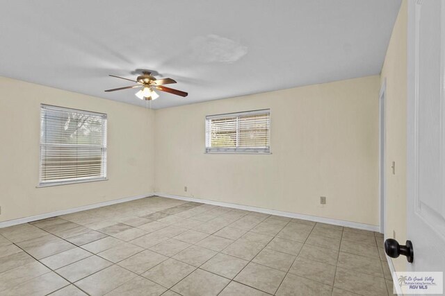 tiled empty room featuring ceiling fan