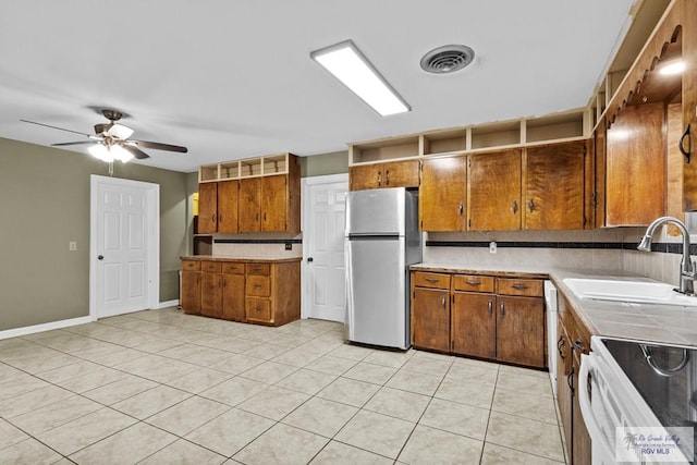 kitchen featuring electric stove, sink, ceiling fan, stainless steel fridge, and light tile patterned flooring