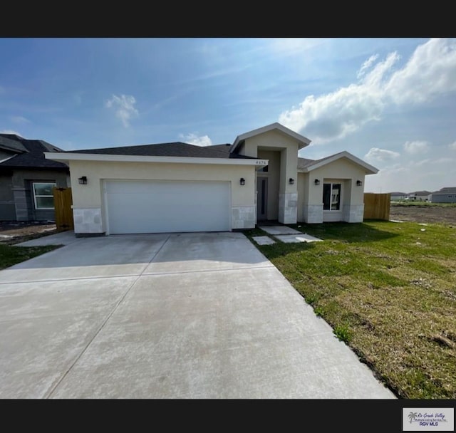 view of front of property featuring stucco siding, driveway, fence, a front yard, and a garage