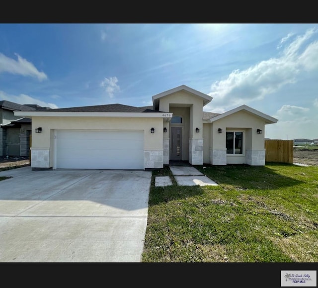 view of front of house with a front lawn, fence, concrete driveway, stucco siding, and an attached garage