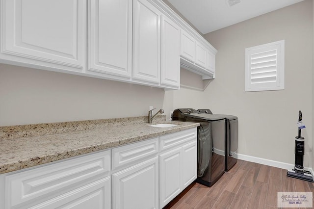 5706 Spicewood, Harlingen, TX 78552 - washroom with washing machine and dryer, cabinet space, and light wood-style floors